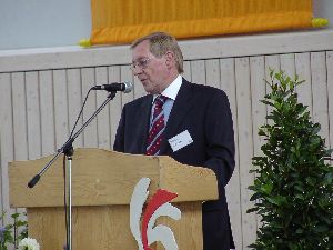 Der Geschäftsführer der Gemeinschaftsaktion bedankt sich beim Staatssekretär und kündigt die Ehrung der Schulweghelfer an