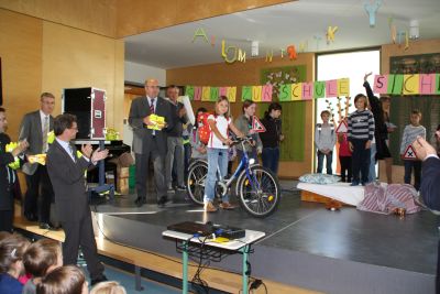 ADAC-Vorstandsmitglied Josef Kaspar berbrachte am Ende eines Verkehrstheaterstckes der Kombiklasse 3c/4c reflektierende Sicherheitswesten fr die Erstklssler. Staatssekretr Bernd Sibler (links) vom Bayerischen Staatsministerium fr Unterricht und Kultus wrdigte die Initiative und half zusammen mit den Vertretern der Partner der Gemeinschaftsaktion bei der Verteilung der Warnwesten