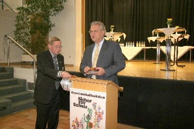 Hier übergibt der Geschäftsführer die von der Gemeinschaftsaktion gestifteten Büchergutscheine und die Gummibärchen für die Kinder“, Walter Schwab