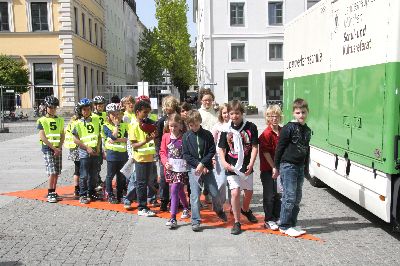 Die gesamte Klasse steht auf der roten Plane und die Schülerin im Fahrzeug kann keinen einzigen ihrer Mitschüler sehen, weil die ganze Klasse im „Toten Winkel“ steht