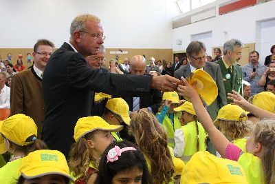Der Staatssekretär und die Ehrengäste verteilen die Baseball-Käppies und Schutzwesten an die ABC-Schützen