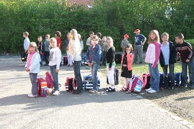 Mustergültig, wie die Buskinder sich anstellen: In einer reihe hintereinander und die Schultasche am Boden