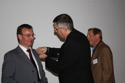 EPHK Hubert Schröder, Innenministerium, übergibt die Symbolfigur als Anstecknadel